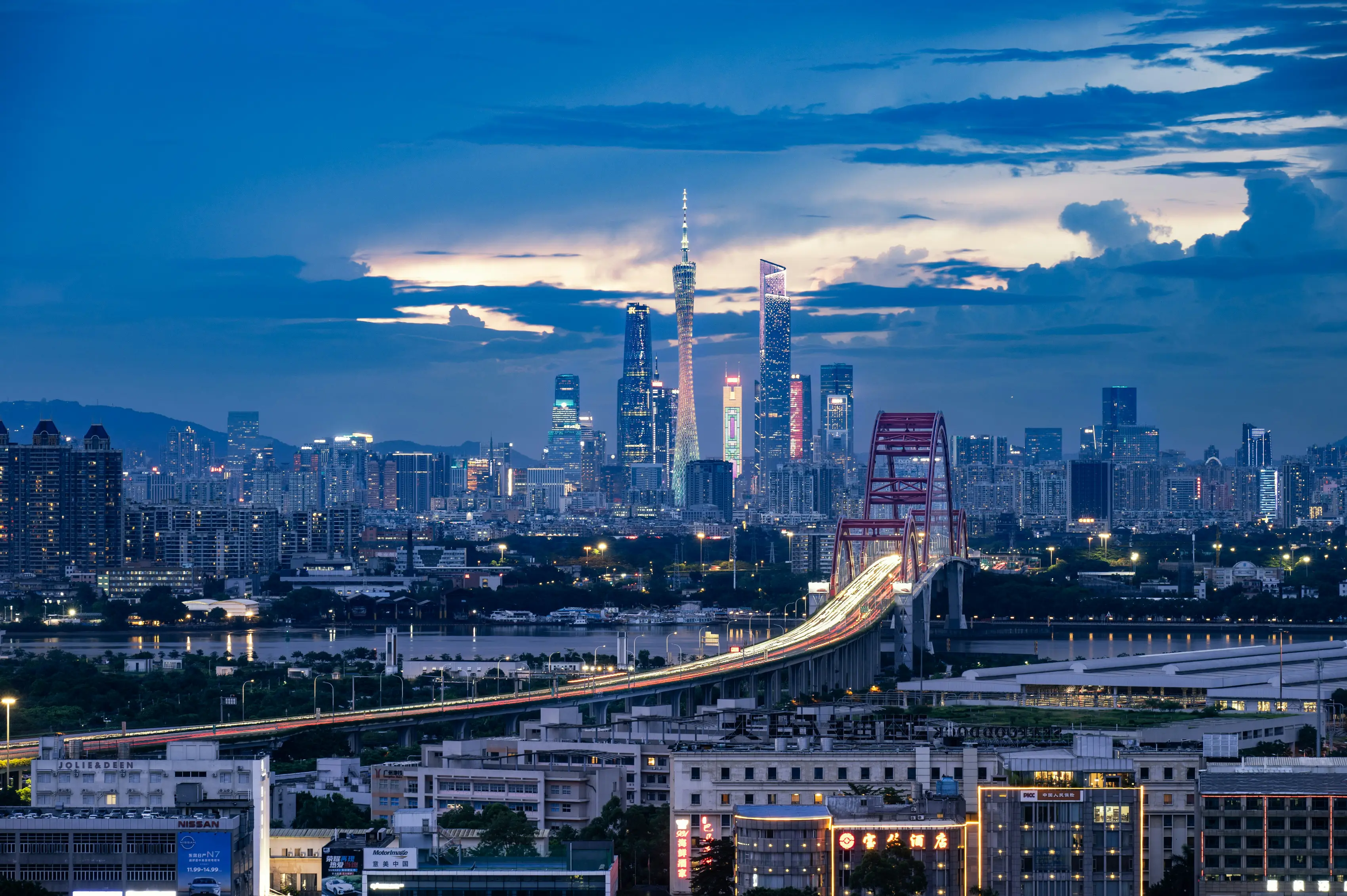 A city skyline at the blue hour, seen from the far bank.