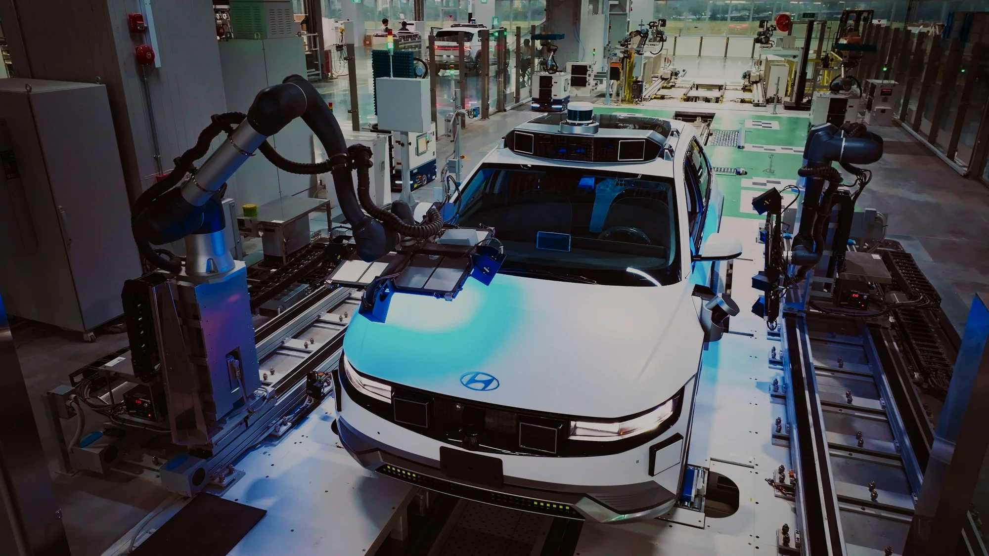 Un vehículo en una línea de montaje robotizada, con los brazos trabajando sobre la carrocería.